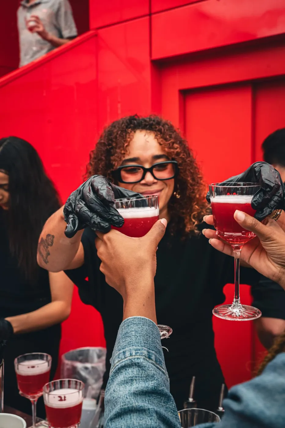 Barmaid Nomade servant des cocktails rouges aux invités